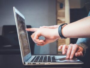 Teammates collaborating on a computer while exploring intelligent search and its impact on modern business operations
