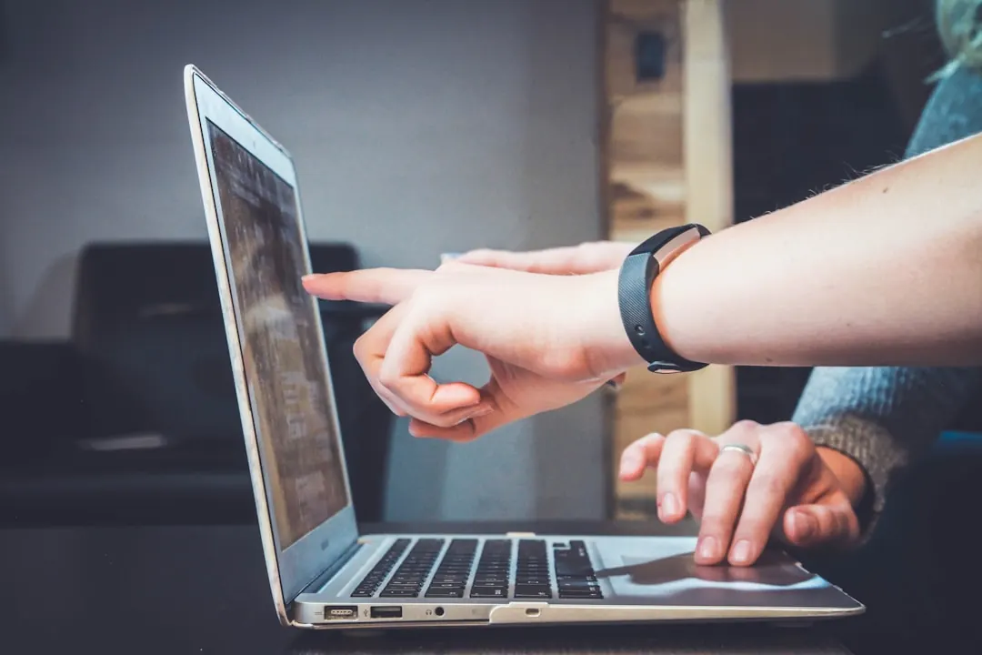 Teammates collaborating on a computer while exploring intelligent search and its impact on modern business operations